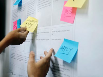 Two hands moving sticky notes to consider if a lead is an mql vs sql